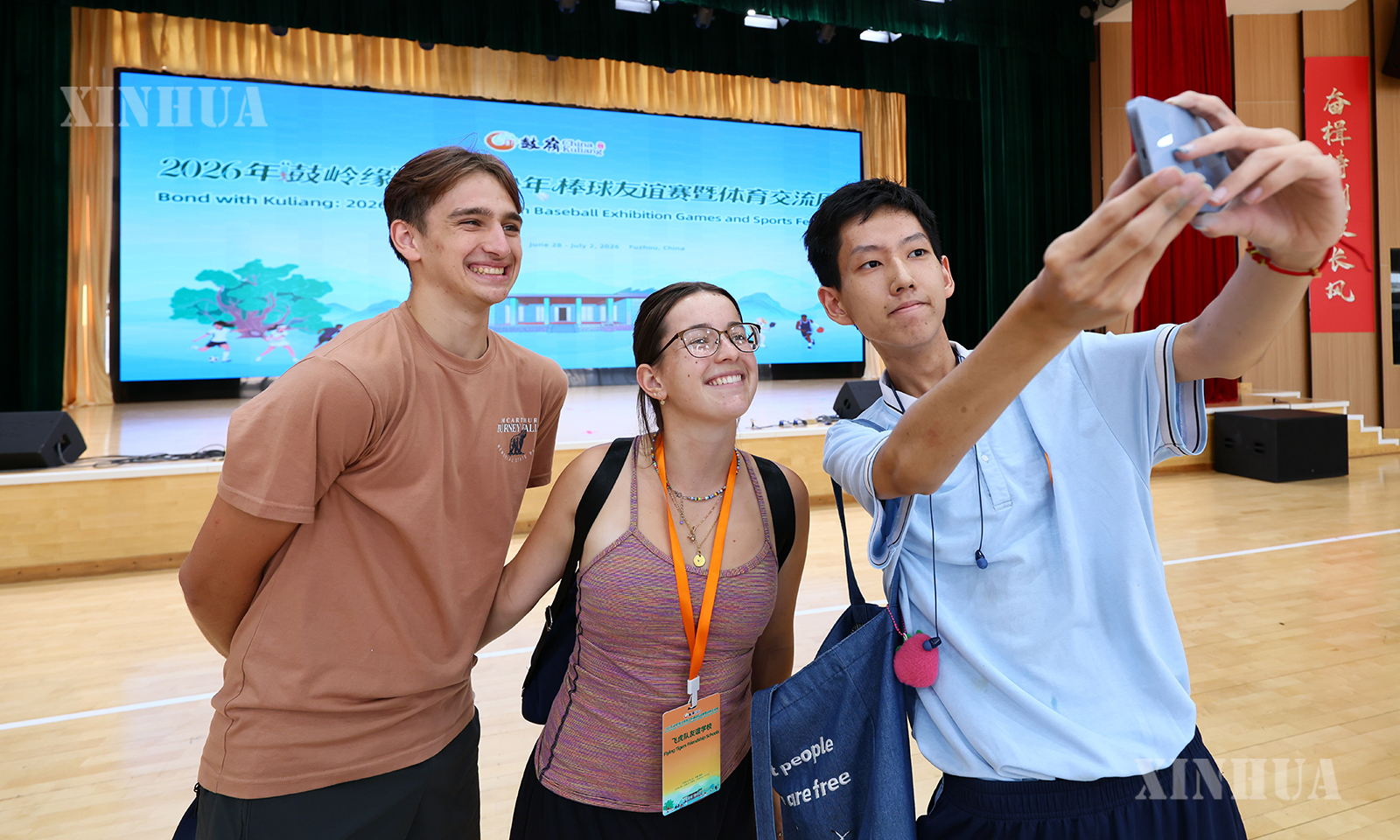 တရုတ်နိုင်ငံ ဖူကျန့်ပြည်နယ် ဖူကျိုးမြိုရှိ ဖိန်တုန်းအလယ်တန်းကျောင်း ကျင်းပသော Flying Tigers ချစ်ကြည်ရေးကျောင်းမှ ဆရာ၊ ဆရာမ၊ ကျောင်းသား၊ ကျောင်းသူများ ကျောင်းဝန်းအတွင်း လာရောက်ခြင်း အစီအစဉ်တွင် ဖူကျိုး အလယ်တန်းကျောင်းမှ ကျောင်းသားတစ်ဦးနှင့် အမေရိကန်လူငယ်နှစ်ဦး ၂၀၂၆ ခုနှစ် ဇွန် ၃၀ ရက်တွင် အမှတ်တရဓာတ်ပုံ ရိုက်ကူးနေစဉ် (ဆင်ဟွာ)