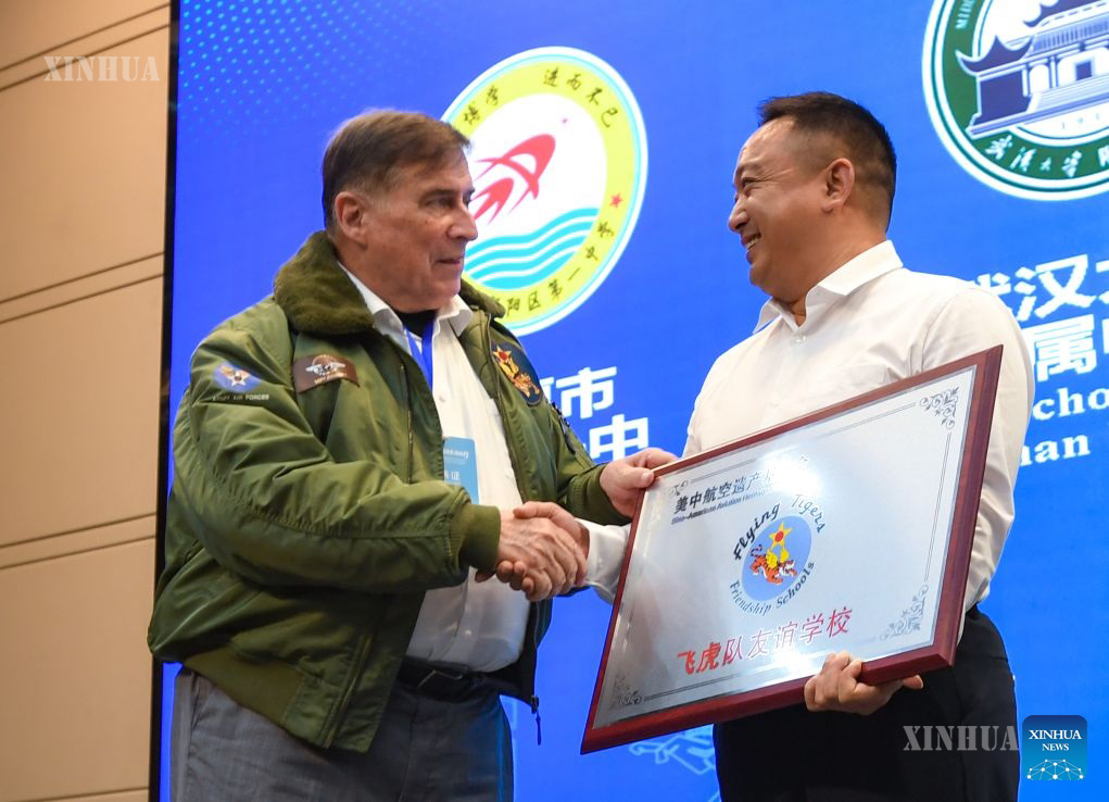 တရုတ်နိုင်ငံ အလယ်ပိုင်း ဟူပေပြည်နယ် ဝူဟန့်မြို့တွင် တရုတ်-အမေရိကန် လေကြောင်းအမွေအနှစ်ဖောင်ဒေးရှင်း ဥက္ကဋ္ဌ ဂျက်ဖရီ ဂရင်း (ဝဲ) က စာသင်ကျောင်း၏ ကိုယ်စားလှယ်အား အထိမ်းအမှတ်မော်ကွန်းကျောက်ပြား လက်ဆောင်ပေးအပ်နေသည်ကို ၂၀၂၆ ခုနှစ် ဇူလိုင် ၃ ရက်က တွေ့ရစဉ် (ဆင်ဟွာ)