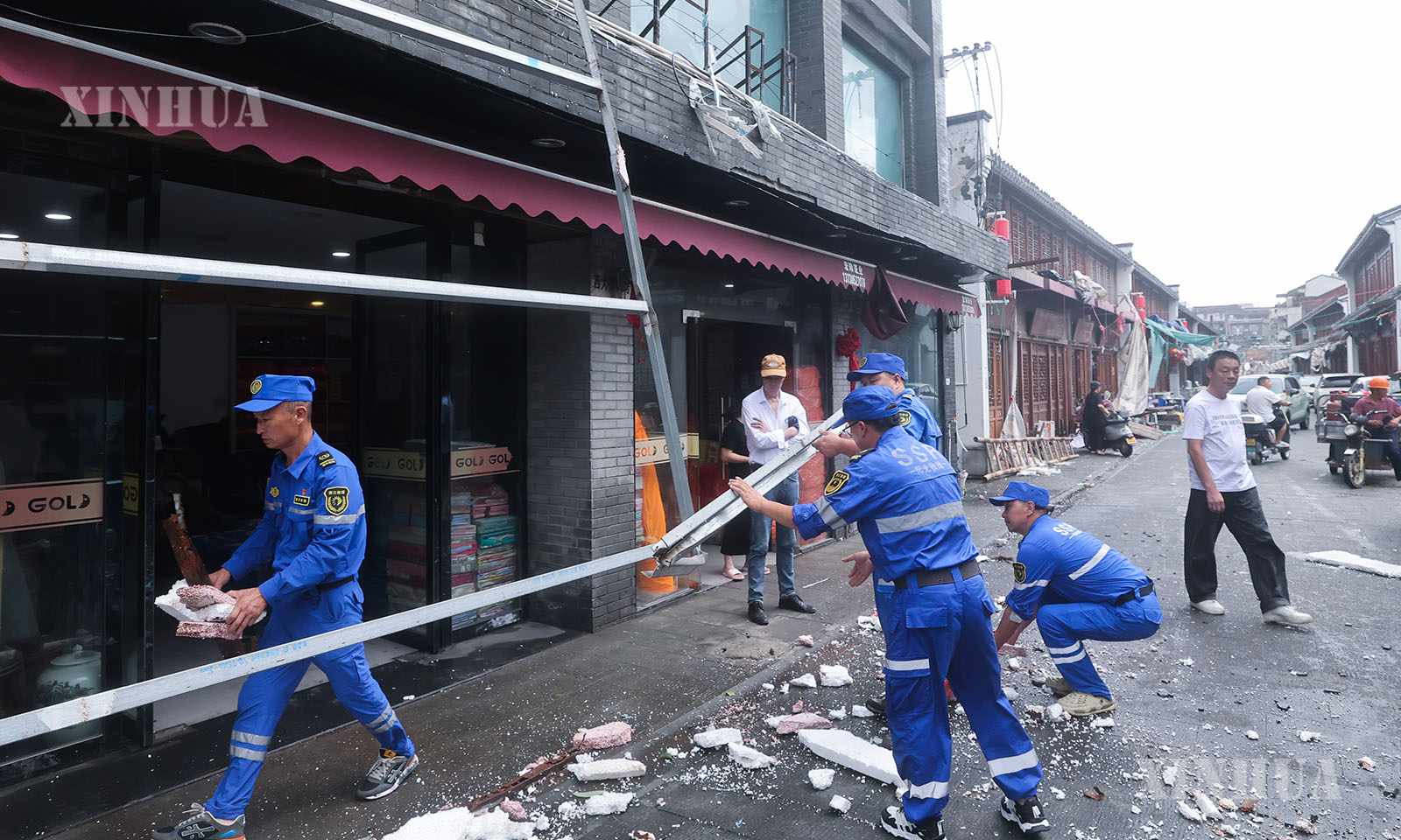 တရုတ်နိုင်ငံ ကျဲ့ကျန်းပြည်နယ်၊ ထိုင်ကျိုးမြို့၊ ယွိဟွမ်မြို့၊ ချူမန်မြို့နယ် လမ်းမထက်တွင် လေတိုက်၍ ပြိုကျသွားသော ဆိုင်းဘုတ်သံမဏိဘောင်ကို အရေးပေါ်တုံ့ပြန်ရေးသမားများက ရှင်းလင်းနေကြသည်ကို ၂၀၂၆ ခုနှစ် ဇူလိုင် ၁၂ ရက်က တွေ့ရစဉ် (ဆင်ဟွာ)