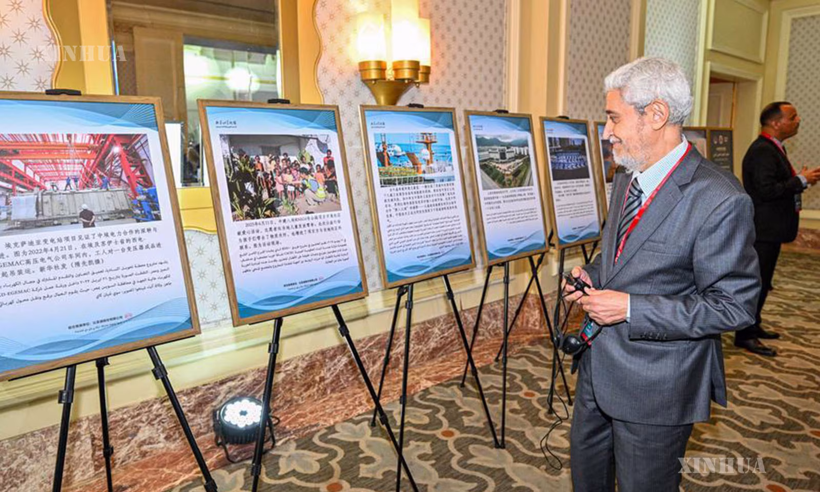 အီဂျစ်နိုင်ငံ ကိုင်ရိုမြို့၌ ကျင်းပသော တရုတ်-အာရပ် အနုပညာပြပွဲ၏ ဓာတ်ပုံပြပွဲ၌ တရုတ်-အာရပ် ပူးပေါင်းဆောင်ရွက်မှုဆိုင်ရာ ခင်းကျင်းပြသမှုများအား ကမ္ဘာ့တောင်ဘက်ခြမ်း မီဒီယာနှင့် Think Tank ဖိုရမ် တရုတ်-အာရပ် မိတ်ဖက်ပူးပေါင်းဆောင်ရွက်မှု ဆွေးနွေးပွဲ တက်ရောက်လာသည့် ဧည့်သည်တော်တစ်ဦးက ကြည့်ရှုနေပုံကို ၂၀၂၆ ခုနှစ် မေ ၁၃ ရက်က တွေ့ရစဉ် (ဆင်ဟွာ)