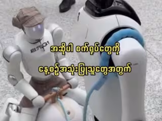 ၂၀၂၆ ခုနှစ် ကမ္ဘာ့ ဉာဏ်ရည်တု ညီလာခံတွင် စက်ရုပ်တစ်ရုပ်က အခြားစက်ရုပ်တစ်ရုပ်ကို လမ်းလျှောက်ခေါ်ဆောင်လာ