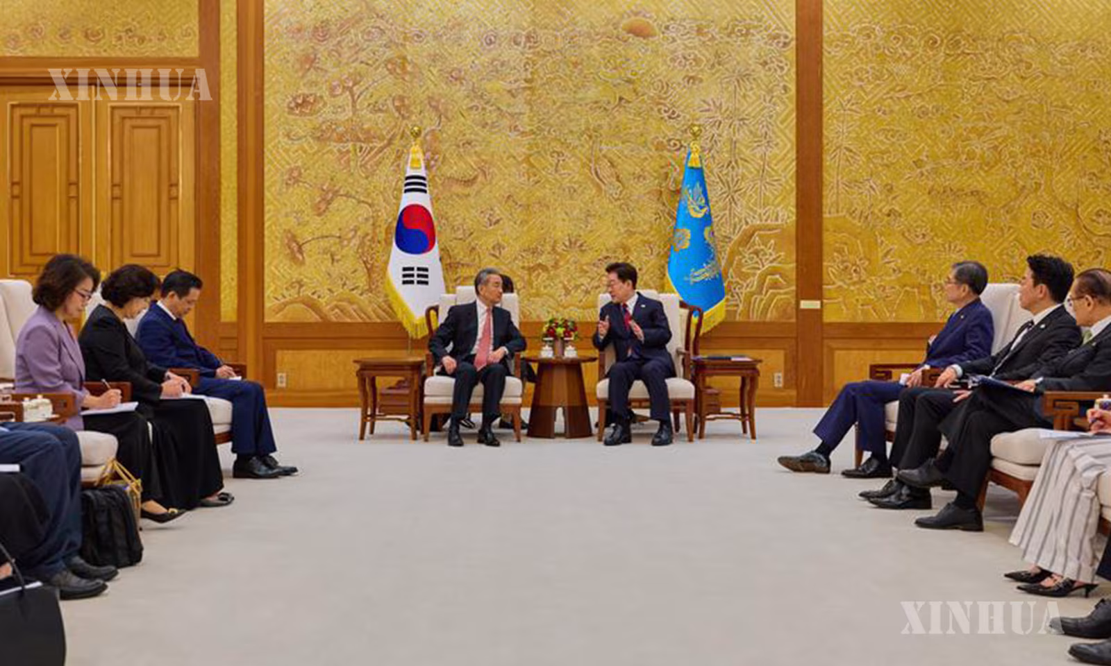 တောင်ကိုရီးယားနိုင်ငံ သမ္မတ လီဂျေမြောင်နှင့် တရုတ်ကွန်မြူနစ်ပါတီ ဗဟိုကော်မတီ နိုင်ငံရေးဗျူရိုအဖွဲ့ဝင်၊ နိုင်ငံခြားရေးဝန်ကြီး ဝမ်ရိ တို့ ၂၀၂၆ ခုနှစ် ဩဂုတ် ၂၀ ရက်တွင် တောင်ကိုရီးယားနိုင်ငံ ဆိုးလ်မြို့ရှိ အိမ်ပြာတော်၌ တွေ့ဆုံဆွေးနွေးစဉ် (ဆင်ဟွာ)